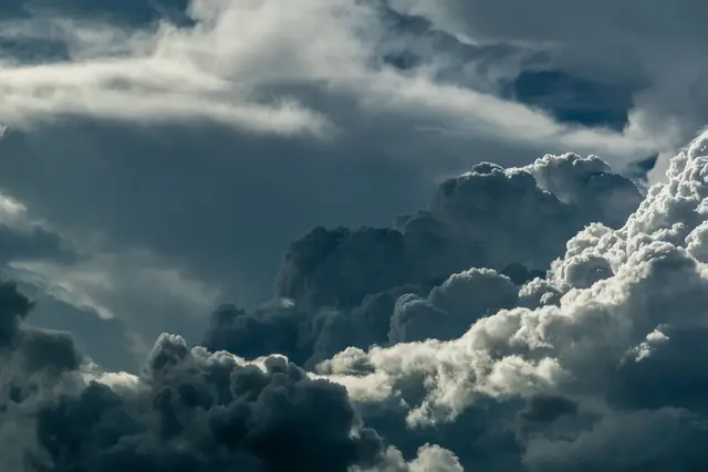 Dramatic storm clouds building against a blue sky.