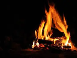 Flames burning in a dark fireplace.