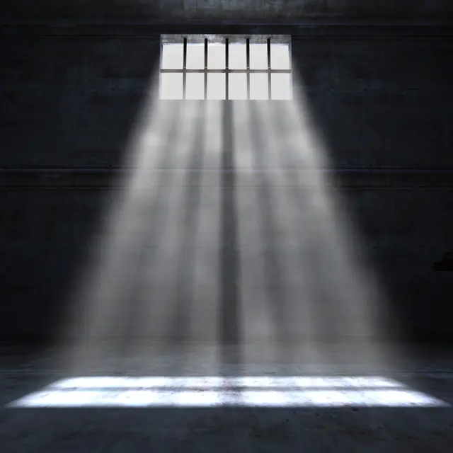 Rendered image of light streaming through a barred window into a dark room.